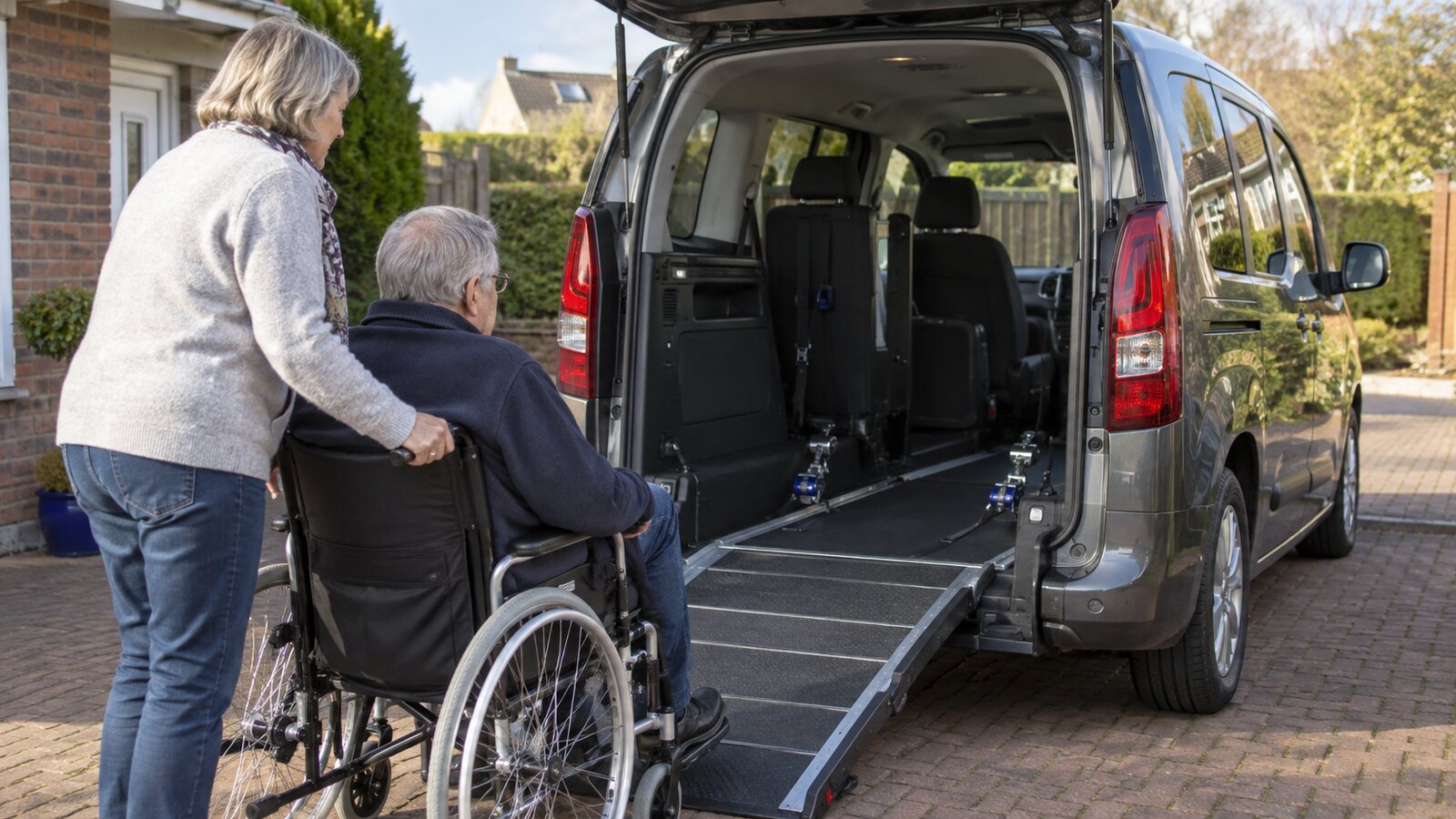 A wheelchair-accessible vehicle with its rear ramp ready on a British driveway
